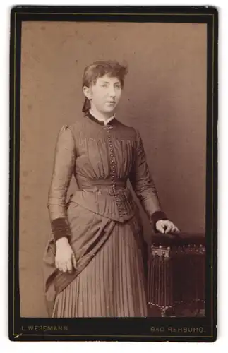 Fotografie L. Wesemann, Bad Rehburg, Junge Dame mit Stirnlocken in elegantem Kleid mit Plissee-Rock