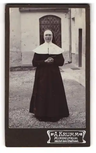 Fotografie A. Krumm, Mindelheim, junge Nonne im Habit posiert im Klosterhof