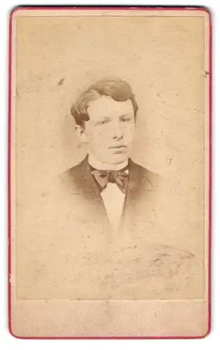 Fotografie A. F. Knoop, Eutin, Jüngling mit Seitenscheitel und grosser Fliege