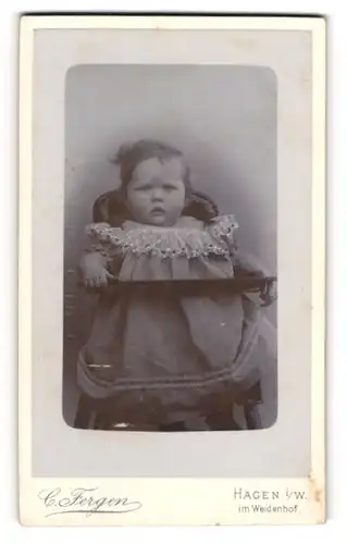 Fotografie c. fergen, Hagen i/W., Mittelstrasse 6, Niedliches Kleinkind im Kleidchen sitzt auf einem Stuhl