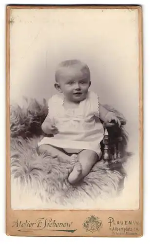 Fotografie F. Siebenow, Plauen i/V., Albertplatz 14, Niedliches Kleinkind im weissen Kleidchen sitzt auf einem Stuhl
