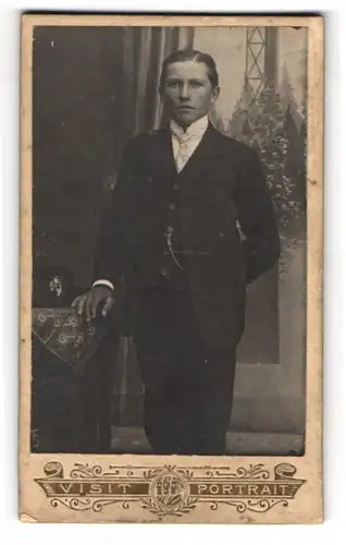 Fotografie unbekannter Fotograf und Ort, Junger bürgerlicher Herr im schwarzen Anzug mit gescheiteltem Haar