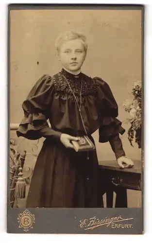 Fotografie E. Bissingen, Erfurt, Anger 25, Hübsche junge Dame im schwarzen Kleid mit Puffärmeln mit kurzem Haar