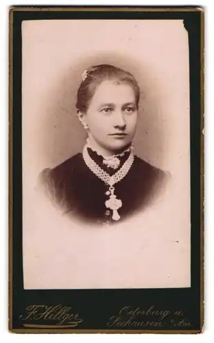Fotografie F. Hilliger, Osterburg, Bürgerliche junge Dame mit Kreuzkette im hochgeschlossenen schwarzen Kleid