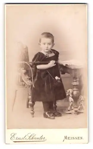 Fotografie Ernst Schroeter, Meissen, Obergasse 597, Kind im Samtkleid mit einem Spielzeugpferd