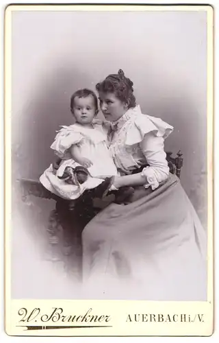 Fotografie W. Bruckner, Auerbach i. V., Mutter im Kleid mit ihrem Kind auf dem Tisch, Mutterglück