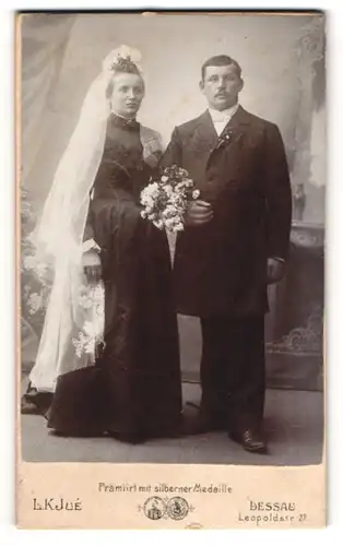 Fotografie L. K. Jue, Dessau, Leopoldstr. 27, anhaltinisches Brautpaar im schwarzen Kleid und Anzug, Brautstrauss