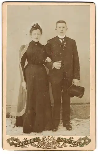 Fotografie unbekannter Fotograf und Ort, junges Ehepaar im schwarzen Hochzeitskleid und Anzug mit Zylinder
