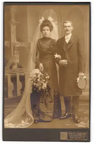 Fotografie Fritz Hacker, Annaberg i. S., Brautpaar im schwarzen Hochzeitskleid und Anzug mit Chapeau Claque