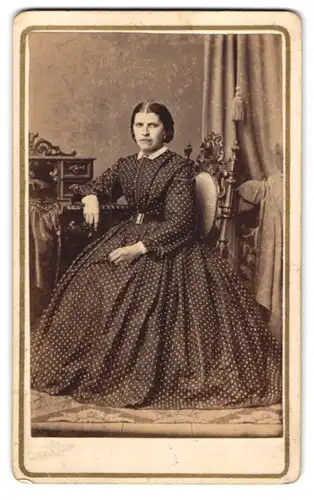 Fotografie F. Tellgmann, Mühlhausen i. Th., Dame im Pünktchenkleid posiert sitzend im Atelier