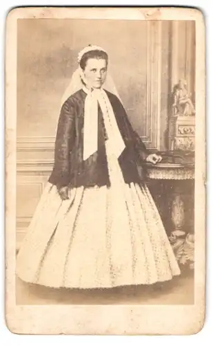 Fotografie Augsut Müthel, Mölln, Bahnhofstr., Portrait junge Frau im hellen Kleid mit dunkler Jacke und Häubchen