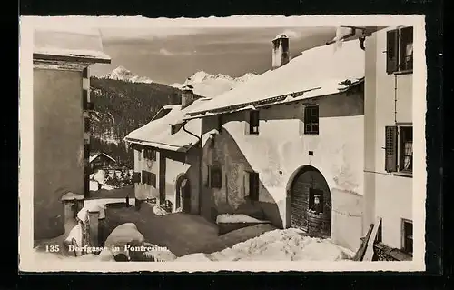 AK Pontresina, Strasse Dorfgasse mit Brunnen im Schnee