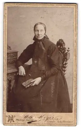 Fotografie Wilh. Meyer, Stade, Schifferthor, Portrait einer elegant gekleideten Frau mit Buch in der Hand