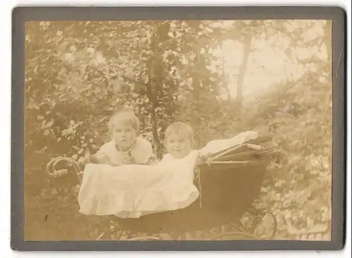 Fotografie unbekannter Fotograf und Ort, zwei niedliche Kinder schauen aus ihrem Kinderwagen, 1915