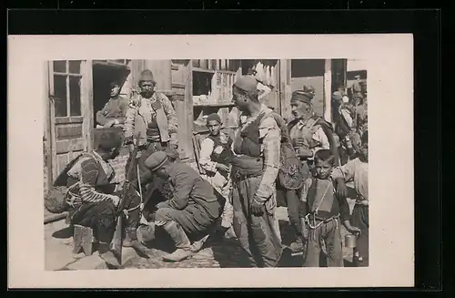 Foto-AK Strassenpartie mit Männern und Kindern, Gewehr