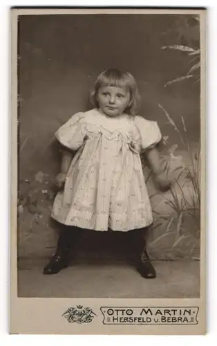 Fotografie Otto Martin, Hersfeld, niedliches Mädchen im Kleid an Wand stehend