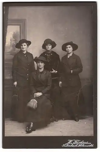 Fotografie W. Fürhaus, Kulmbach, vier Damen in schwarzen Kleidern mit Hüten und Handtaschen
