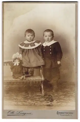 Fotografie Otto Langner, Crimmitschau, zwei niedliche kleine Kinder mit grosser Puppe im Atelier