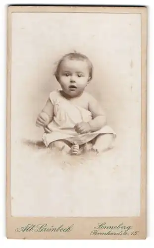 Fotografie Alb. Grünbeck, Sonneberg, Bernhardstr. 15, Portrait süsses Baby im weissen Hemdchen