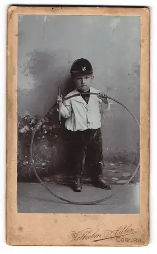 Fotografie Wilhelm Adler, Coburg, Allee 6, Portrait frecher Bube mit Stab und Reifen