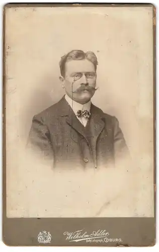 Fotografie Wilhelm Adler, Coburg, Charmanter Herr mit Zwicker und Schnauzbart
