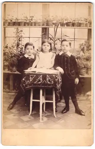 Fotografie unbekannter Fotograf und Ort, Mädchen und zwei Jungen in modischer Kleidung