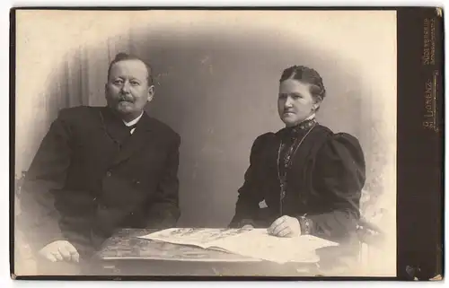 Fotografie A. Lorenz, Süderbrarup, Schleswigerstr. 6, Bürgerliches Paar mit Zeitung am Tisch
