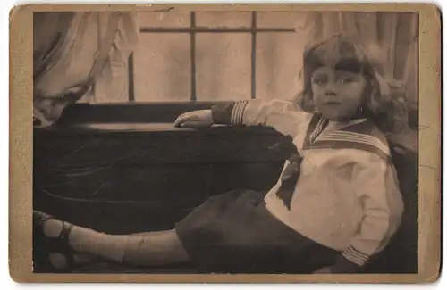 Fotografie unbekannter Fotograf und Ort, Kind im Matrosenhemd sitzt am Fenster