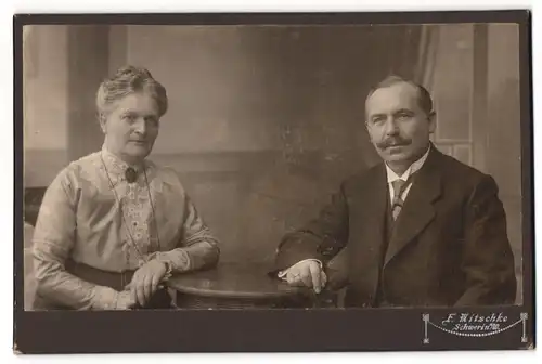 Fotografie E. Mitschke, Schwerin a. W., Älteres Paar in hübscher Kleidung am Tisch