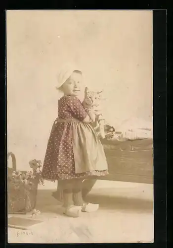 AK Kleines Mädchen in Holzschuhen mit Katze im Arm