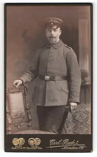 Fotografie Carl Beste, Minden i. W., Bäckerstrasse, Gestandener Soldat mit Schirmmütze in Uniform