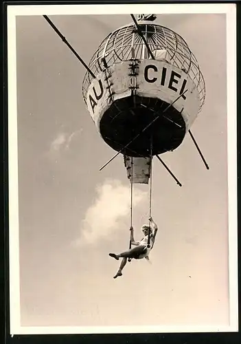 Fotografie Donderer, Berlin, Zirkus-Akrobatin auf Schaukel unter Käfig an einem Kranseil baumelnd