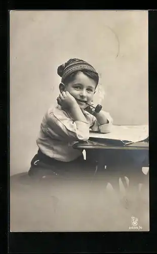AK Knabe mit qualmender Pfeife an einem Tisch