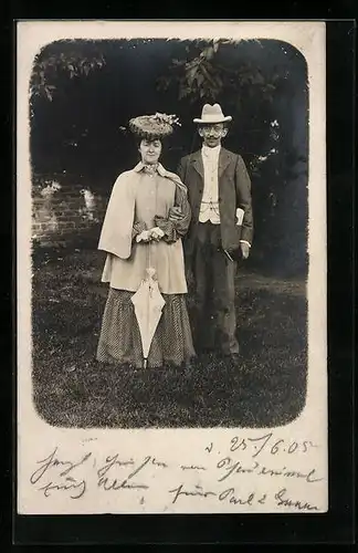 AK Elegantes Paar in einem Park, Dame mit Schirm