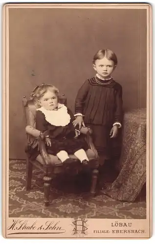 Fotografie H. Strube & Sohn, Löbau i. S., Blumenstr. 339 s, Kleines Mädchen im Kleid mit Geschwisterkind