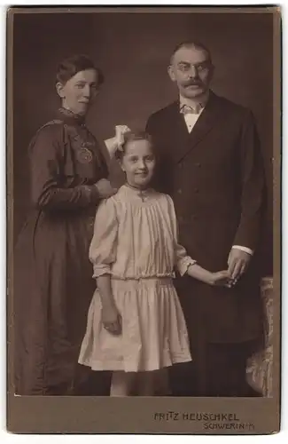 Fotografie Fritz Heuschkel, Schwerin i. M., Wismarsche Str. 34, Bürgerliches Paar mit einem Mädchen