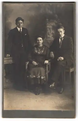 Fotografie unbekannter Fotograf und Ort, Junge Dame im Kleid mit zwei Herren