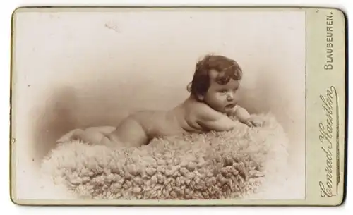 Fotografie Conrad Kaestlen, Blaubeuren, Wonneproppen mit Babyspeck auf einem Fell