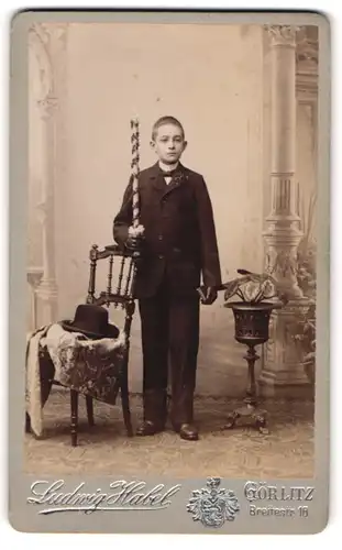 Fotografie Ludwig Habel, Görlitz, Breitestr. 18, junger Knabe zur konfirmation mit Kerze posiert im Atelier