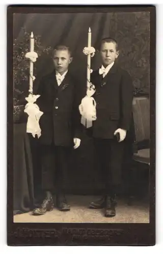 Fotografie J. Hotter, Markt Oberdorf, zwei junge Knaben in dunklen Anzügen mit Kommunionskerze