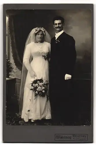 Fotografie H. A. WEnning, Wasserburg, Ehepaar im Hochzeitskleid und Anzug mit Zylinder