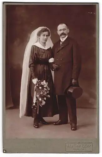 Fotografie Atelier Eder, Kempten, Hochzeitspaar im schwazen Brautkleid und Anzug mit Zylinder