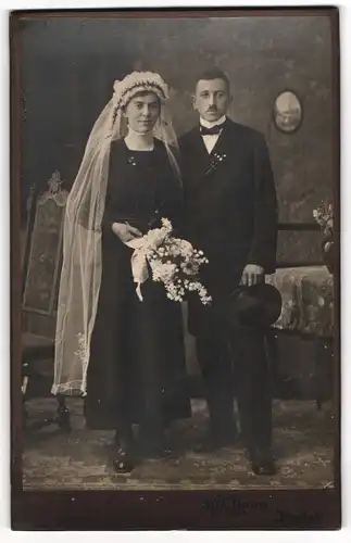 Fotografie Wilh. Amann, Rastatt, Hochzeitspaar im schwarzen Brautkleid und Anzug mit Zylinder
