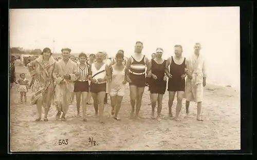 AK Arm in Arm am Strand entlang, Bademode tragende Frauen und Männer