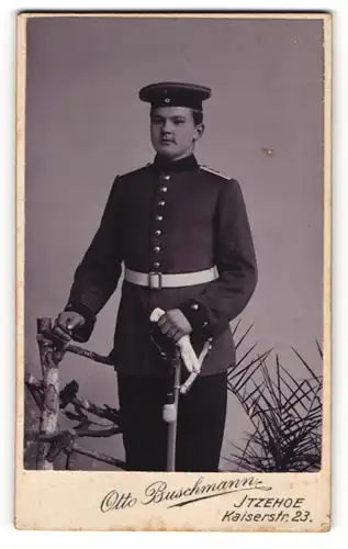 Fotografie Otto Buschmann, Itzehoe, Kaiserstrasse 23, Junger Soldat mit Krätzchen, Säbel und Portepee in Uniform