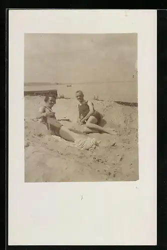 AK Paar liegt in Bademode am Strand