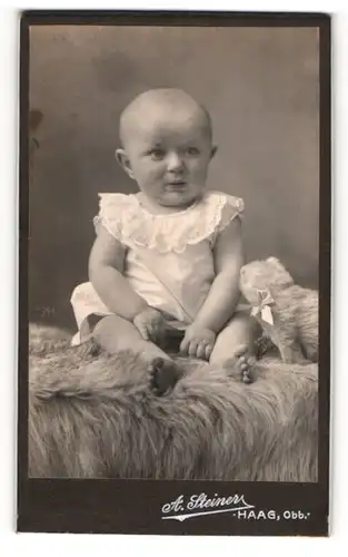 Fotografie A. Steiner, Haag /Obb., Kleinkind im Hemd sitzt auf einem Fell