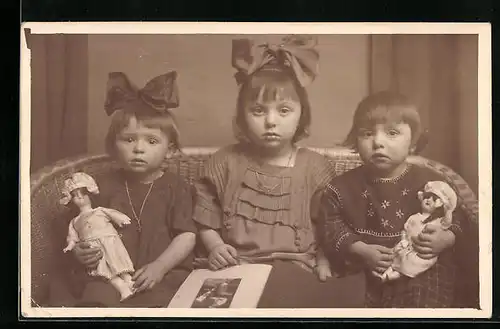 Foto-AK Drei kleine Mädchen mit Puppen auf einem Korbmöbel