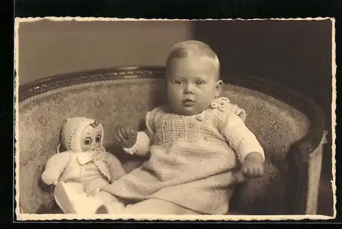 Foto-AK Kleinkind mit Puppe in einem Sessel