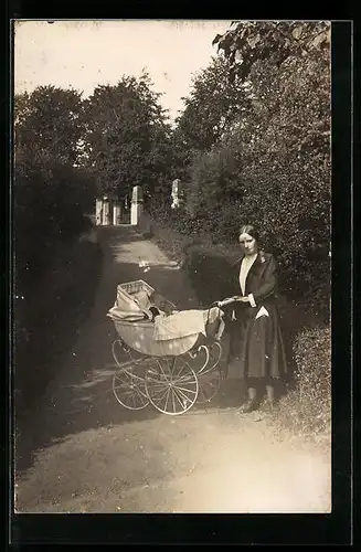Foto-AK Frau mit einem kleinen Kind im Kinderwagen